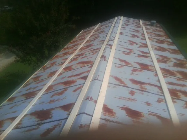 Rusted metal roof panels with new wood purlins before replacement — Storm Damage Roof Repair in Fombell by Roofing Brothers