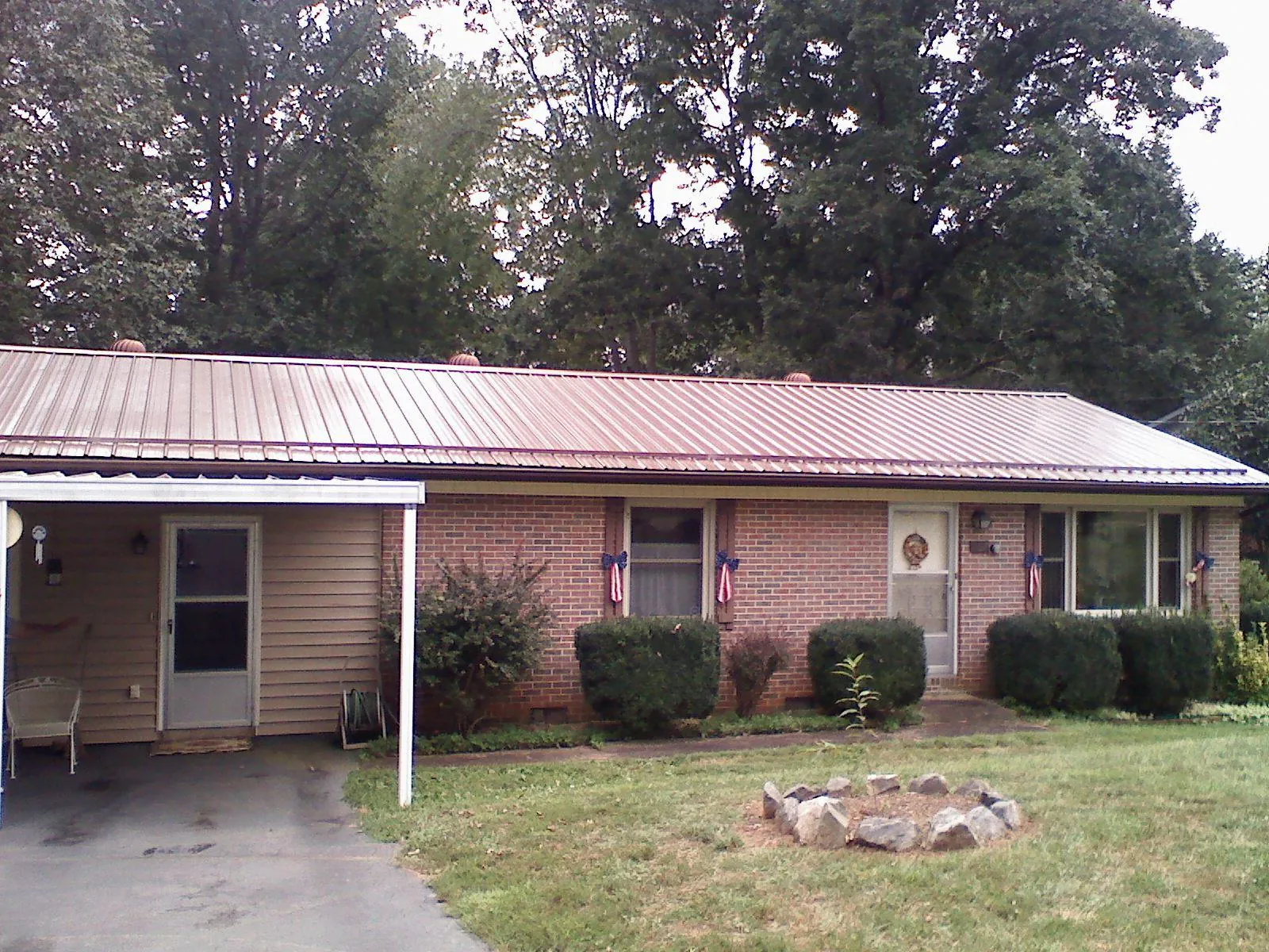 Bronze metal roof and carport on a brick ranch home — Roof Repair work by our crew in Fombell